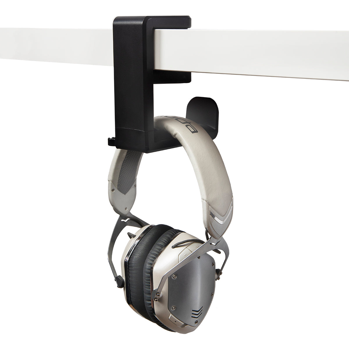 Black plastic headphone hanger clamped to desk with white headphones hanging from it