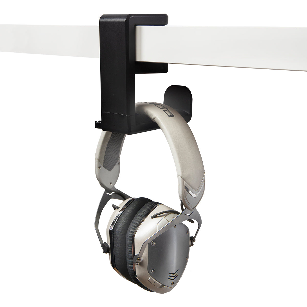 Black plastic headphone hanger clamped to desk with white headphones hanging from it 